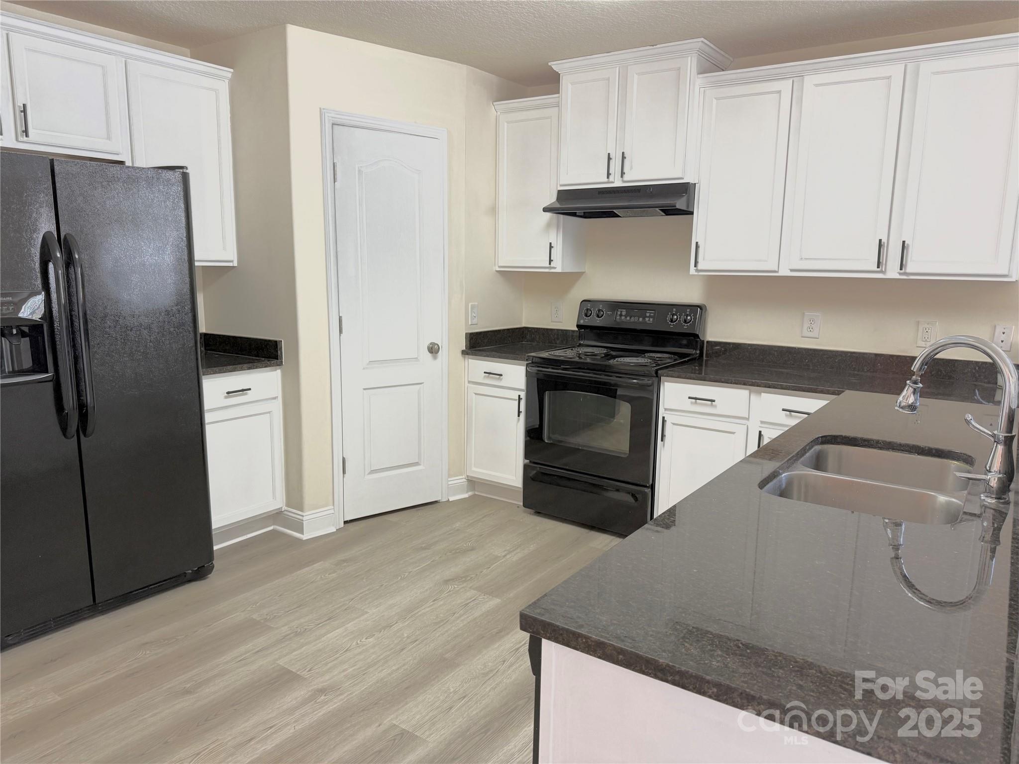7534 April Mist Trail Huntersville, NC 28078 - Photo 7 of 47 a kitchen with granite countertop a refrigerator stove and sink