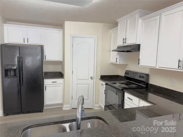 a kitchen with stainless steel appliances granite countertop a refrigerator and a stove