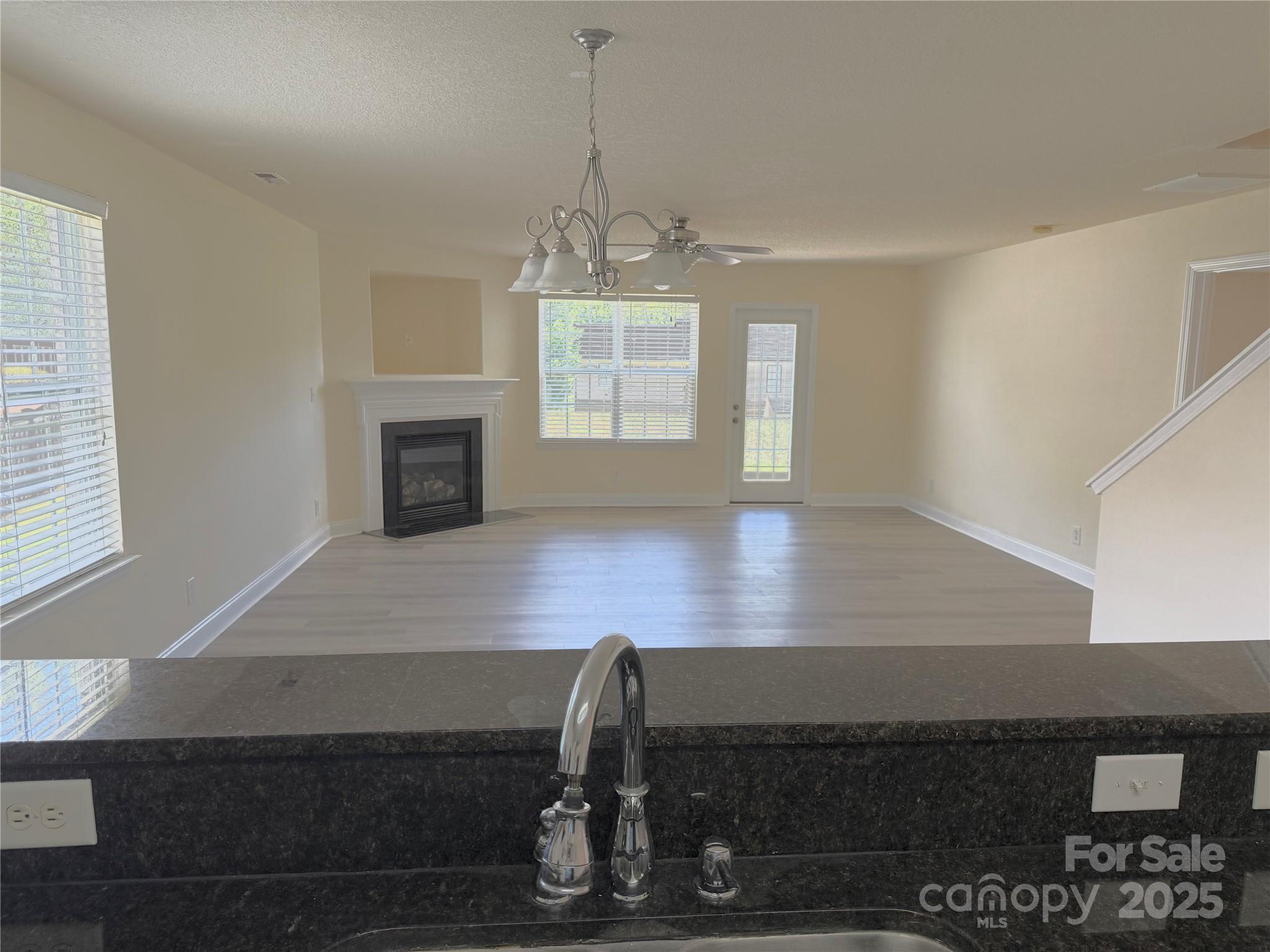 7534 April Mist Trail Huntersville, NC 28078 - Photo 9 of 47 a view of an empty room with wooden floor and a window