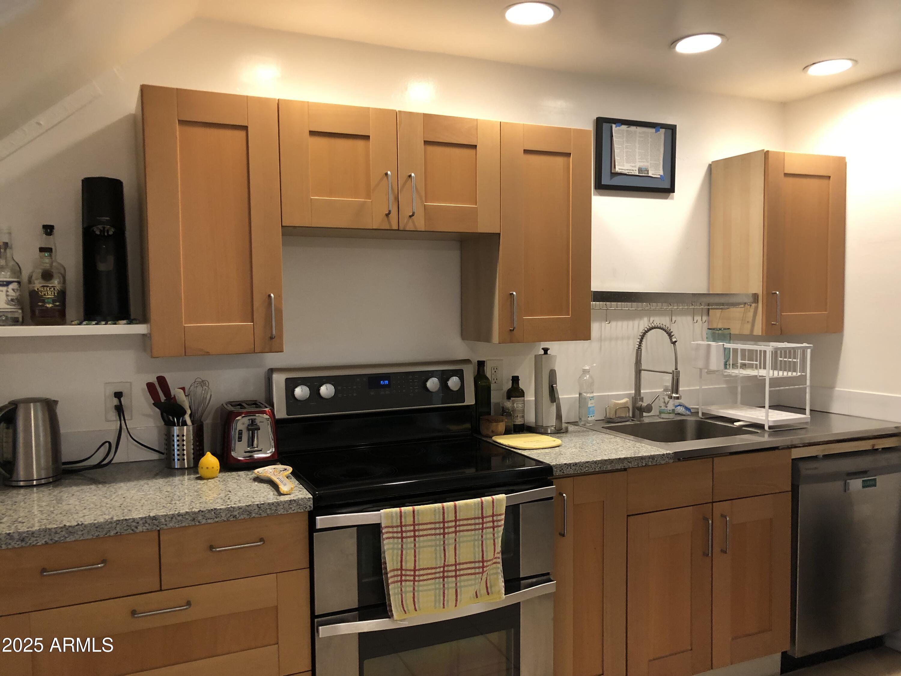 2025 South Granada Drive, Unit 12 Tempe, AZ 85282 - Photo 16 of 35 a kitchen with stainless steel appliances granite countertop a sink stove and cabinets