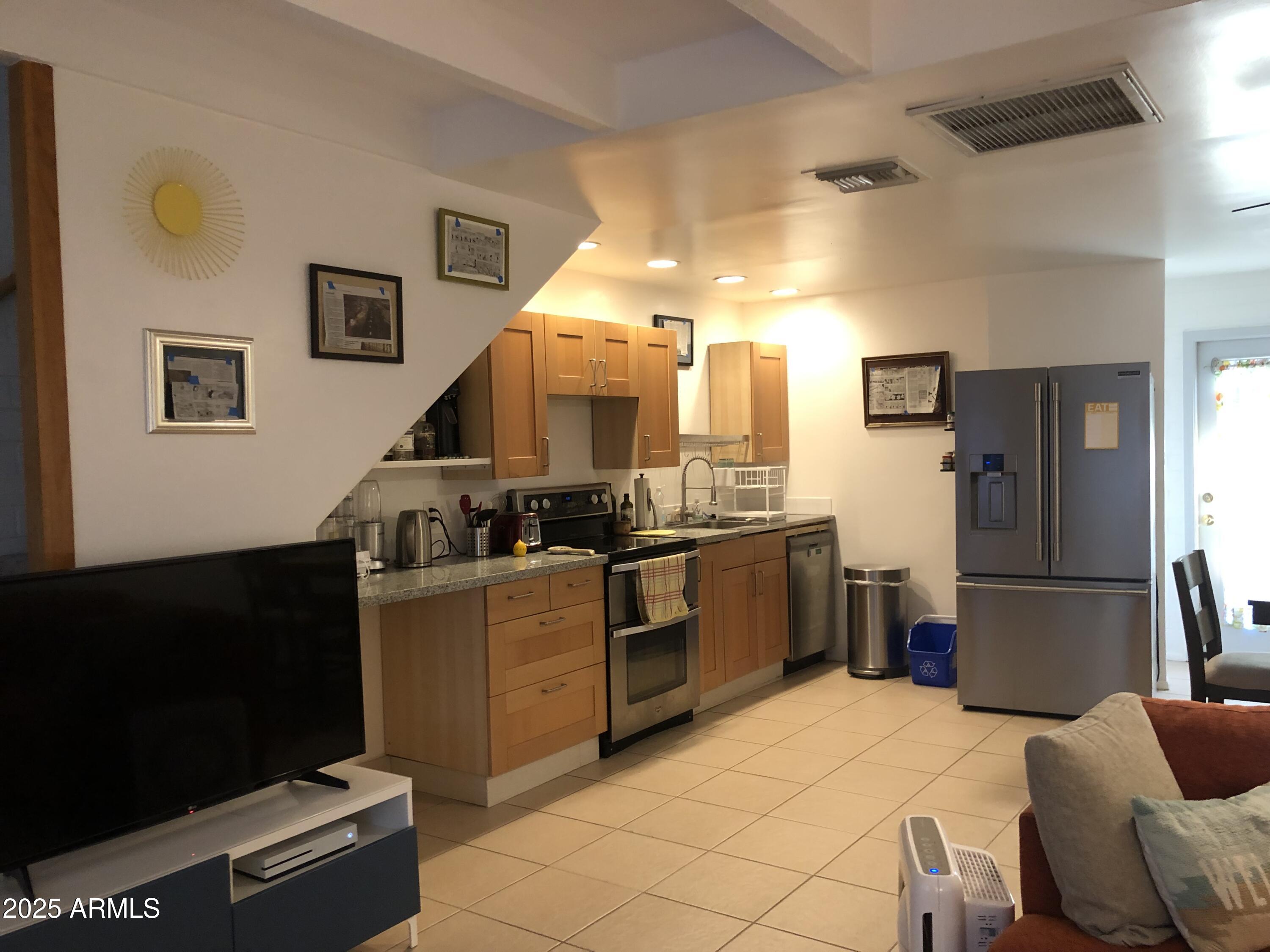 2025 South Granada Drive, Unit 12 Tempe, AZ 85282 - Photo 17 of 35 a kitchen with granite countertop a refrigerator and a stove