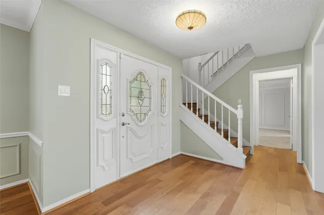 a view of a hallway with entryway wooden floor and front door