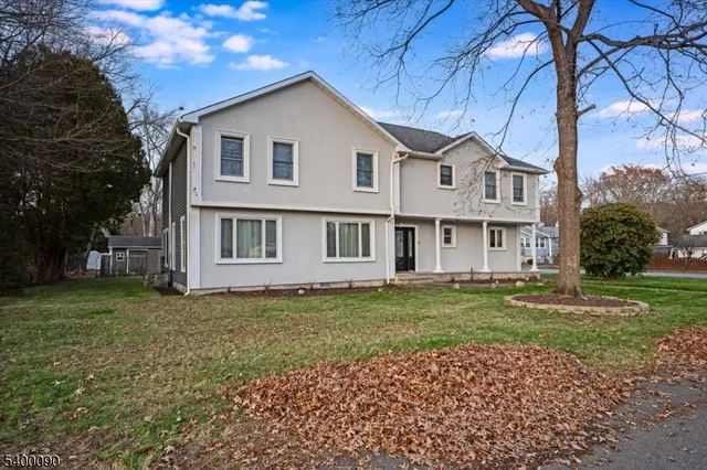 a view of a yard in front of a house with a large tree
