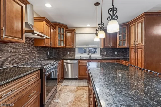 a kitchen with stainless steel appliances granite countertop a stove a sink and a microwave