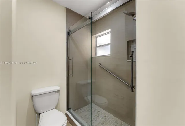 a bathroom with a toilet and a shower