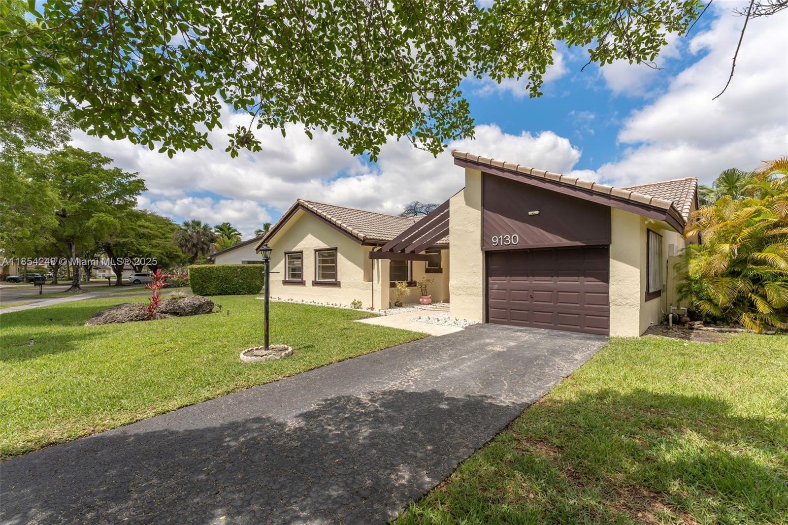 9130 Southwest 101st Avenue Miami, FL 33176 - Photo 2 of 35 a front view of a house with a yard and garage