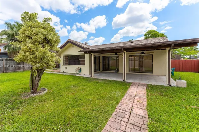 a front view of a house with a garden and yard