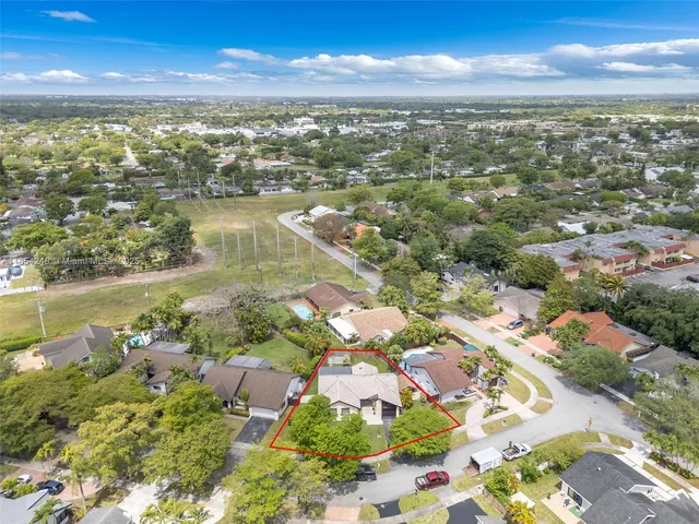 an aerial view of residential houses with outdoor space and lake view