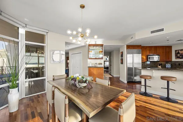 a view of a dining room and livingroom with furniture wooden floor and a chandelier