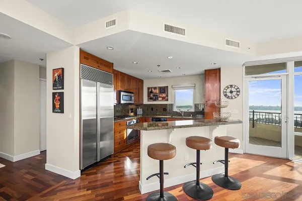 a kitchen with stainless steel appliances granite countertop a refrigerator and a stove top oven