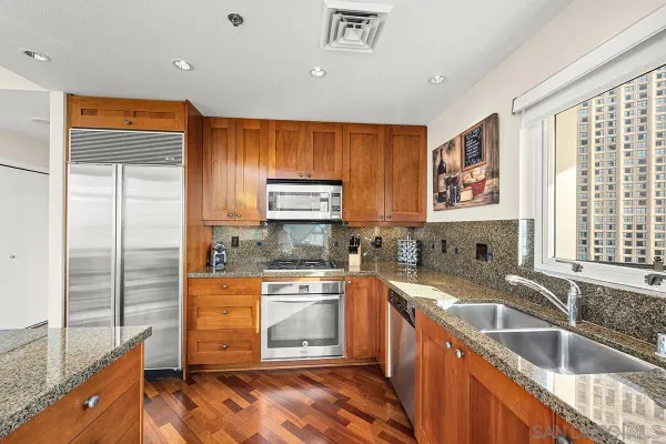 a kitchen with stainless steel appliances granite countertop a sink stove and refrigerator