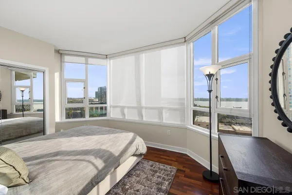 a bedroom with a bed mirror table and window