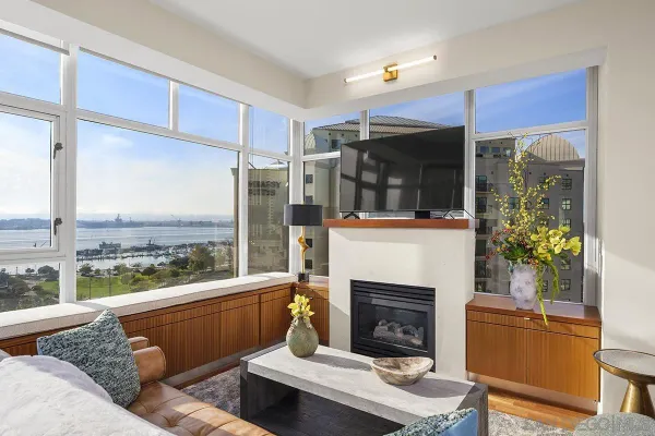 a living room with furniture a fireplace and a floor to ceiling window