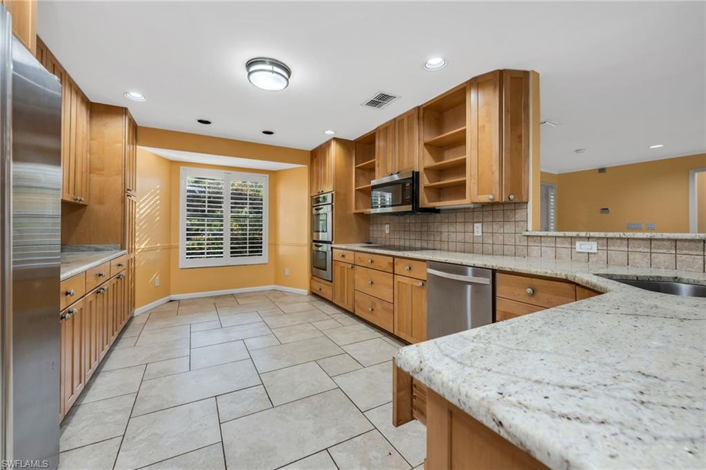 5191 Mahogany Ridge Drive Naples, FL 34119 - Photo 10 of 18 a kitchen with stainless steel appliances granite countertop a sink and dishwasher a oven with granite countertops