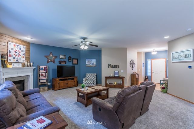 a living room with furniture a fireplace and a flat screen tv
