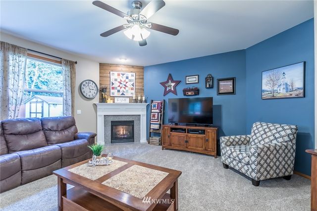 a living room with furniture a flat screen tv and a fireplace