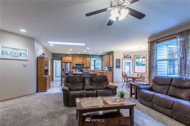 a living room with furniture a ceiling fan and a window