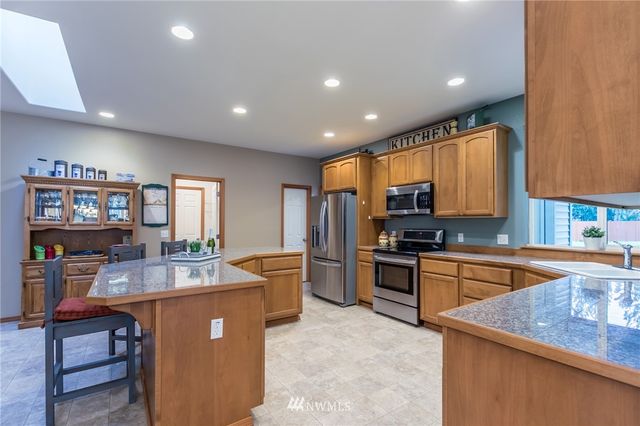 a kitchen with stainless steel appliances granite countertop sink stove and refrigerator