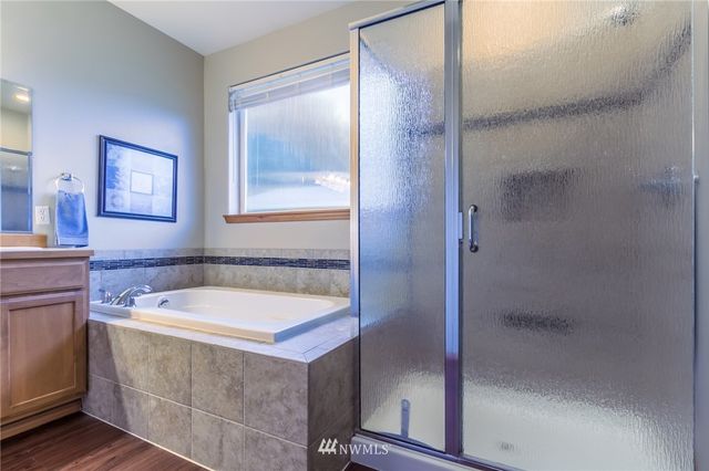 a bathroom with a tub a sink and mirror