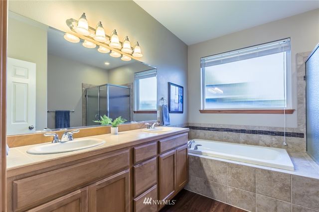 a spacious bathroom with a tub sink and a mirror