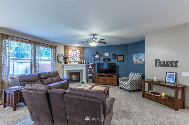 a living room with furniture a fireplace and a flat screen tv