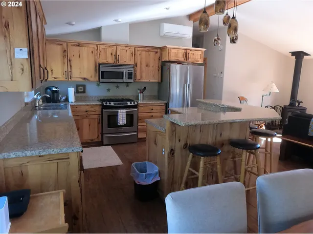 a kitchen with stainless steel appliances granite countertop a sink refrigerator and microwave