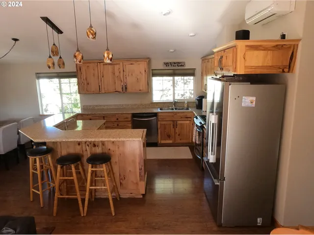 a kitchen with a table chairs refrigerator and window