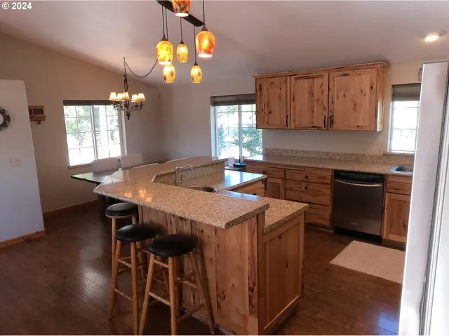 a kitchen that has a cabinets a sink stainless steel appliances and window