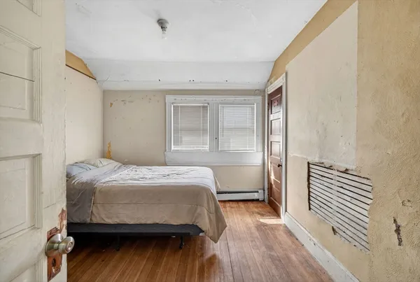 a bedroom with a bed and wooden floor