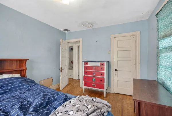 a bedroom with a bed and wooden floor
