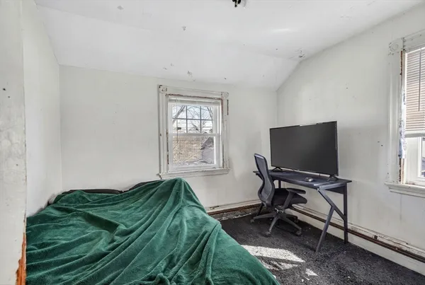 a bedroom with a bed and a window