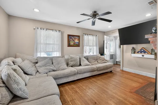 a living room with furniture ceiling fan and a window