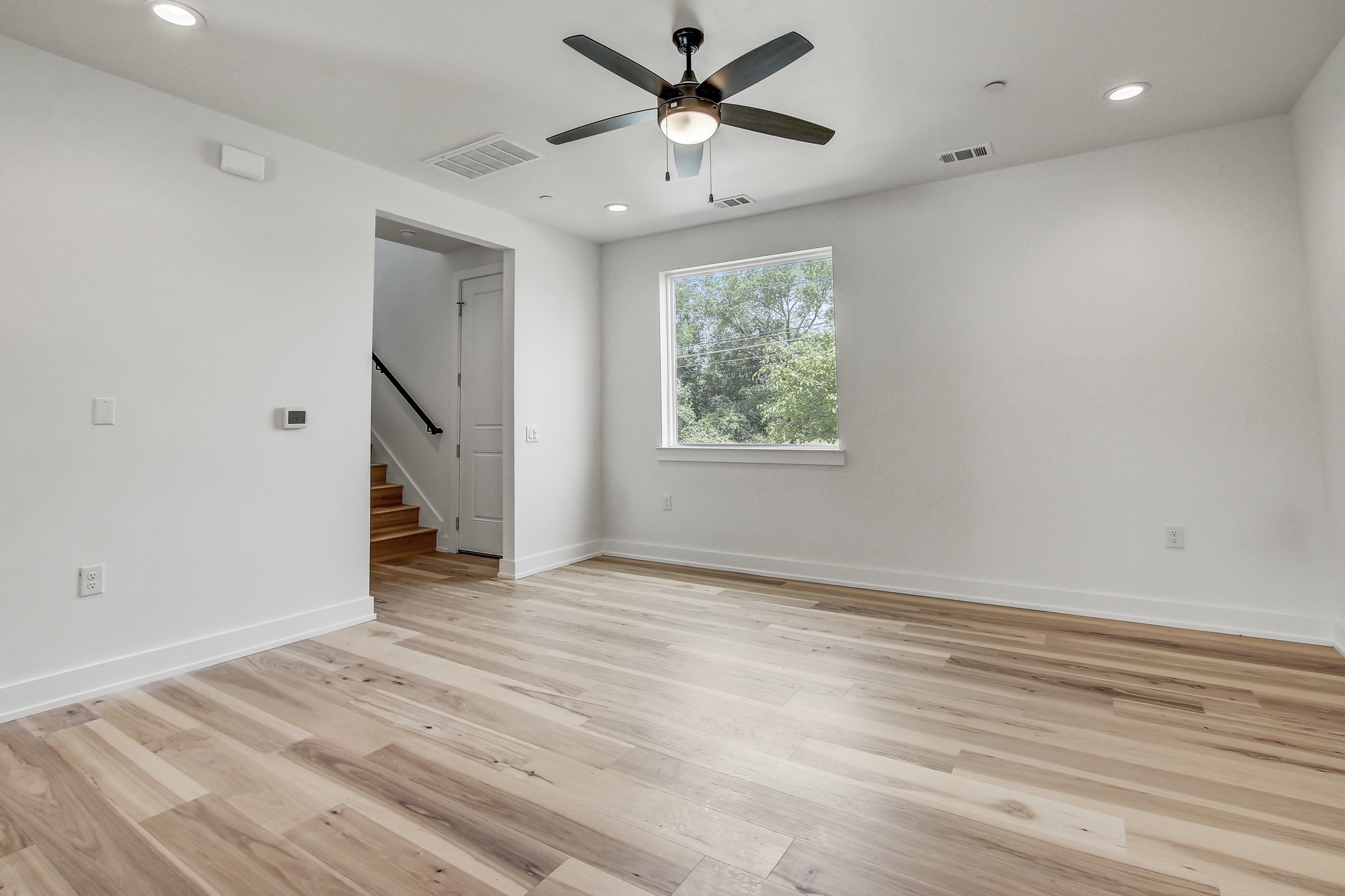4127 East 12th Street, Unit 4 Austin, TX 78721 - Photo 3 of 32 Spare room with a ceiling fan, light wood-style flooring, recessed lighting, stairway, and baseboards