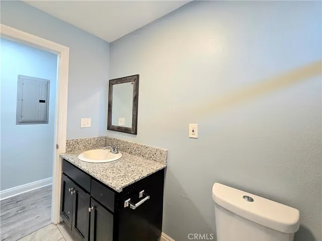 a bathroom with a granite countertop sink and a toilet