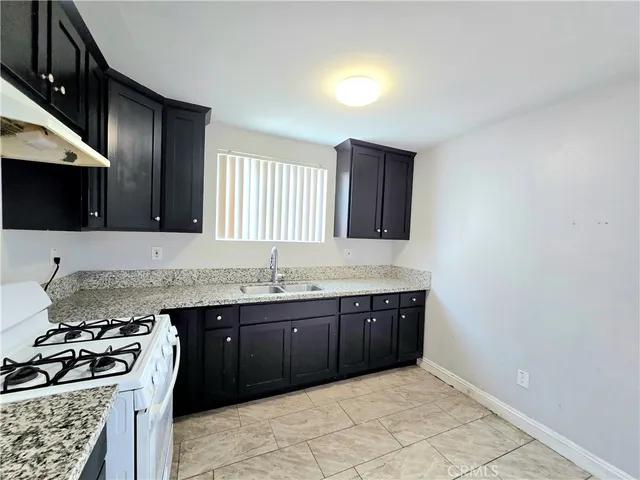 a kitchen with stainless steel appliances granite countertop a sink stove and cabinets