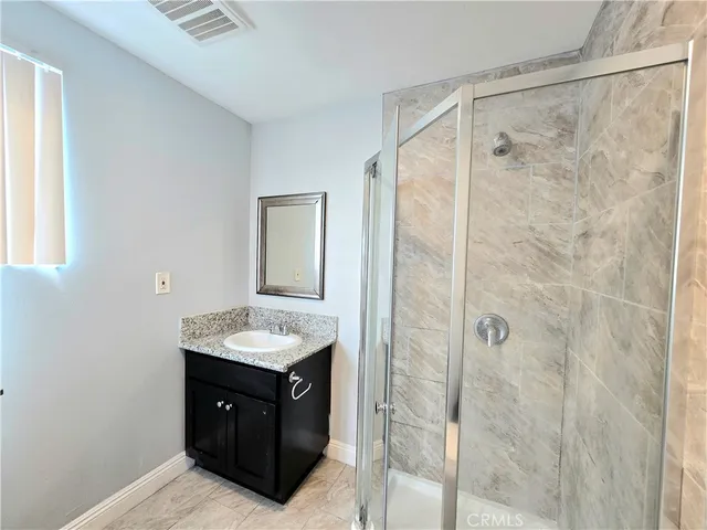 a bathroom with a granite countertop sink shower and a mirror