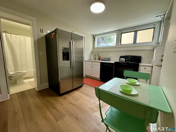 a kitchen with stainless steel appliances granite countertop a refrigerator a stove and a wooden floors