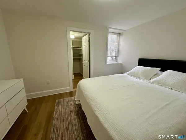 a bedroom with a bed and wooden floor