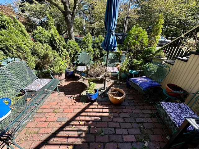 a view of a backyard with chairs and potted plants