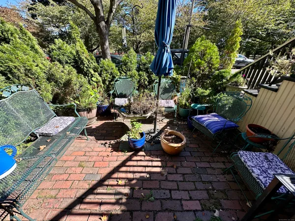 a view of a backyard with chairs and potted plants