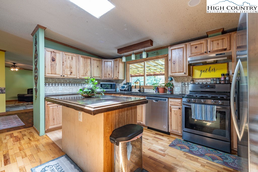285 Roaring Fork Road Todd, NC 28684 - Photo 14 of 41 a kitchen with stainless steel appliances granite countertop a stove and a sink
