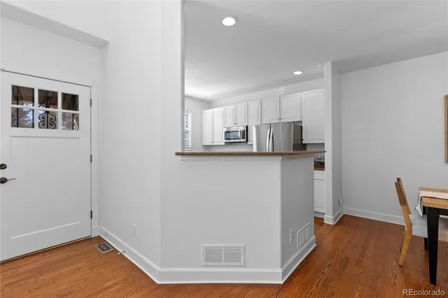 a view of a kitchen with wooden floor and electronic appliances