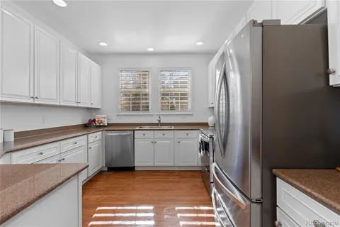 a kitchen with granite countertop a refrigerator and a sink