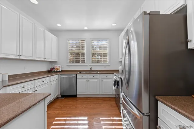 a kitchen with granite countertop a refrigerator and a sink