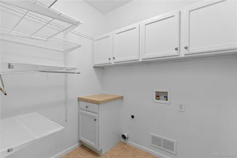 a view of cabinets and utility room with closet