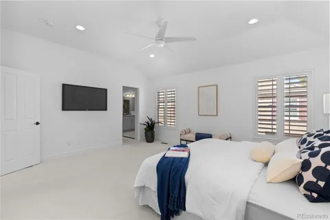 a bedroom with a bed tv and a window