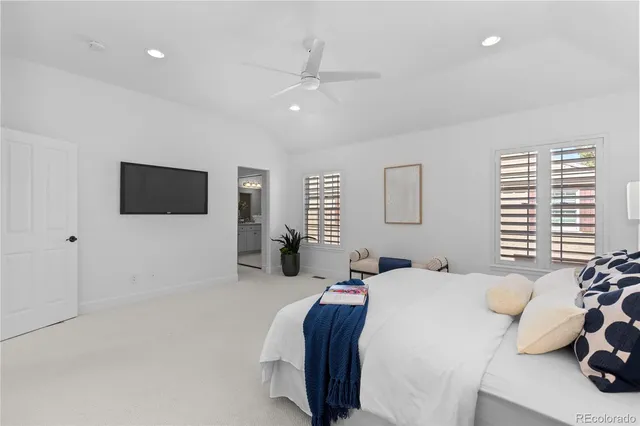 a bedroom with a bed tv and a window