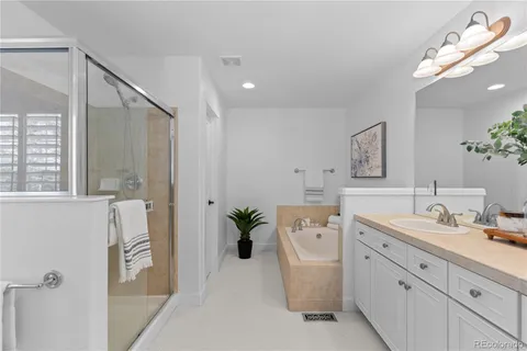 a spacious bathroom with a double vanity sink a mirror and a bathtub