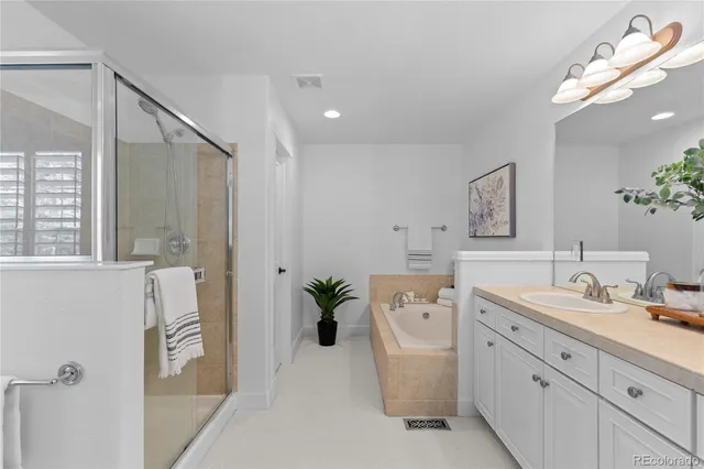 a spacious bathroom with a double vanity sink a mirror and a bathtub