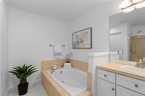 a bathroom with a tub a sink and a mirror